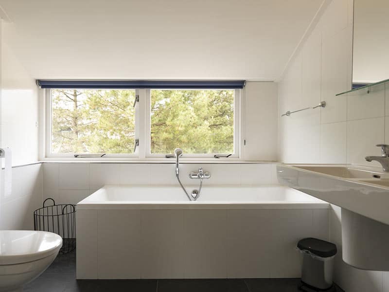 Luxe badkamer met dubbele wastafels, ligbad en douche