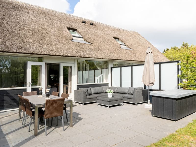 Ruim terras met loungebanken en eettafel