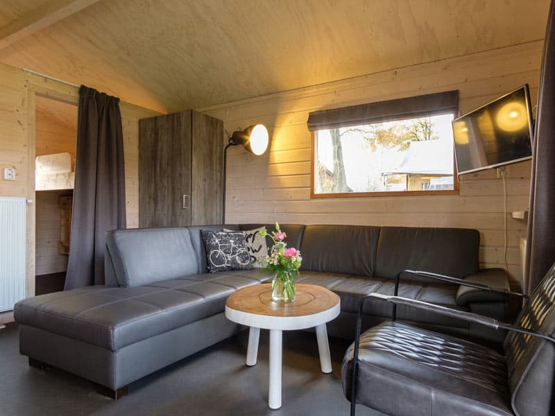 De ruime woonkamer met zithoek en flatscreen tv