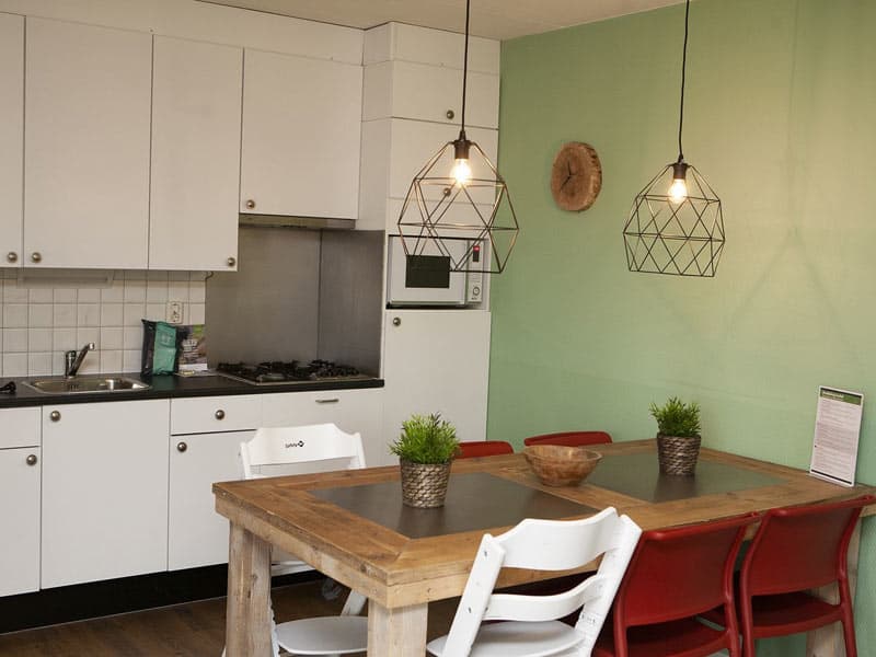 Impressie van de eethoek en keuken in de kinderbungalow voor 7 personen op de Boshoek