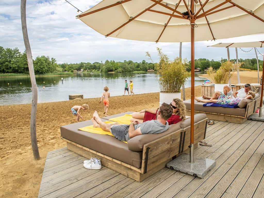 Impressie van het meer en de beachbar op vakantiepark BreeBronne in Maasbree, Noord-Limburg