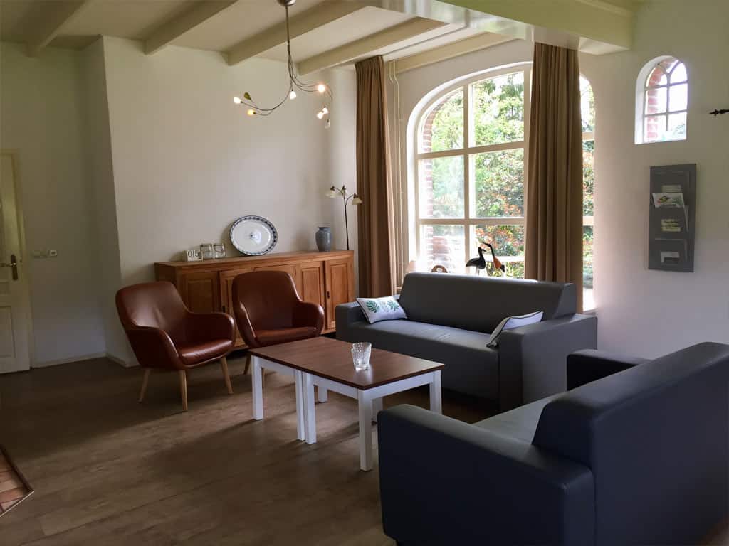 Impressie van de woonkamer in het 8-persoons vakantiehuis 'boerderij Het Jachthuis' op Ardoer Camping De Noetselerberg